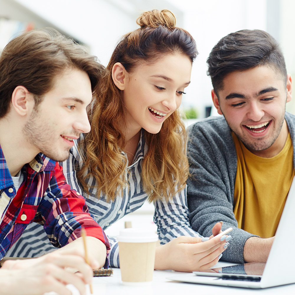 Estudante em ambiente universit&aacute;rio usando tecnologia durante os estudos.